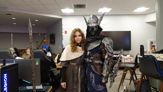 Two attendees in Halloween costumes pose together in the Esports Arena.